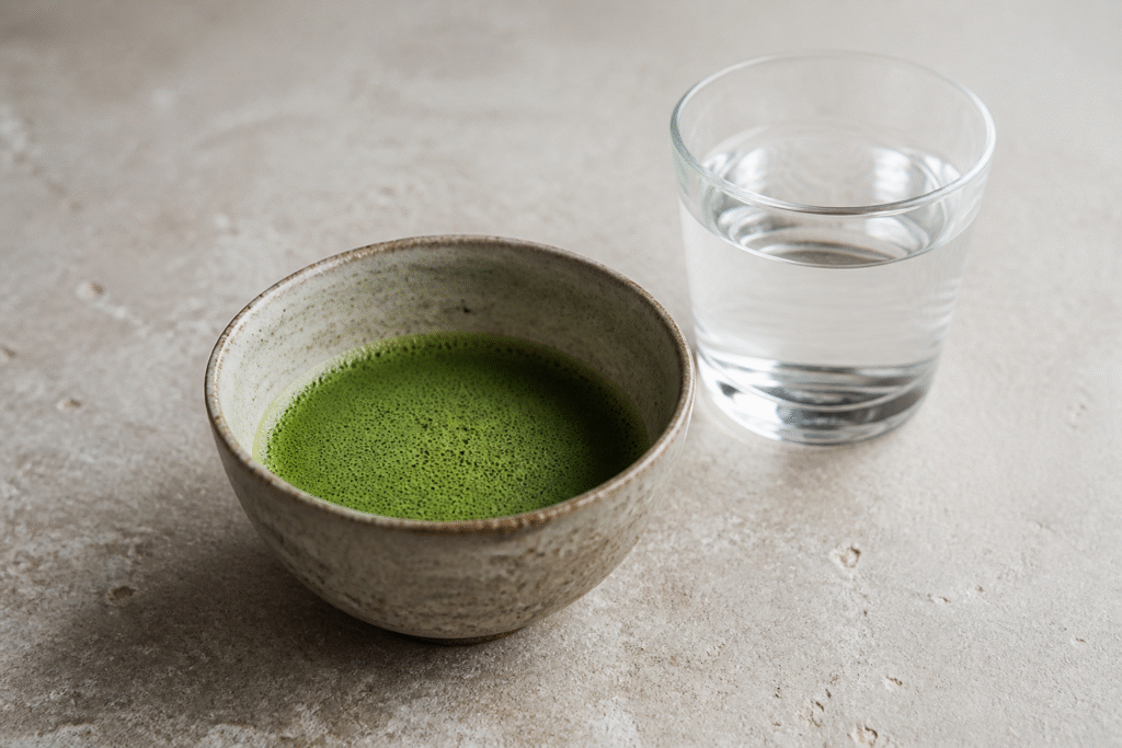 Bowl of plain whisked matcha beside water